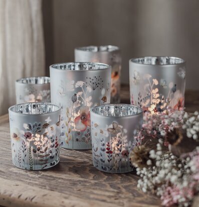 Bild: Frostade ljuslyktor med blomster på rustikt träbord