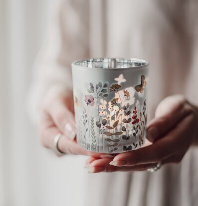 Bild av handhållen ljuslykta med blommor och fjärilsmotiv