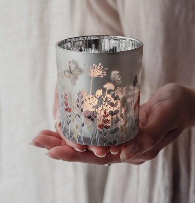 Bild av handhållen ljuslykta med blommor och fjärilar i pastell