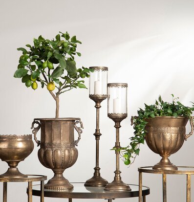 Bild med antika ljuslyktor och urnor i mässingsfinish