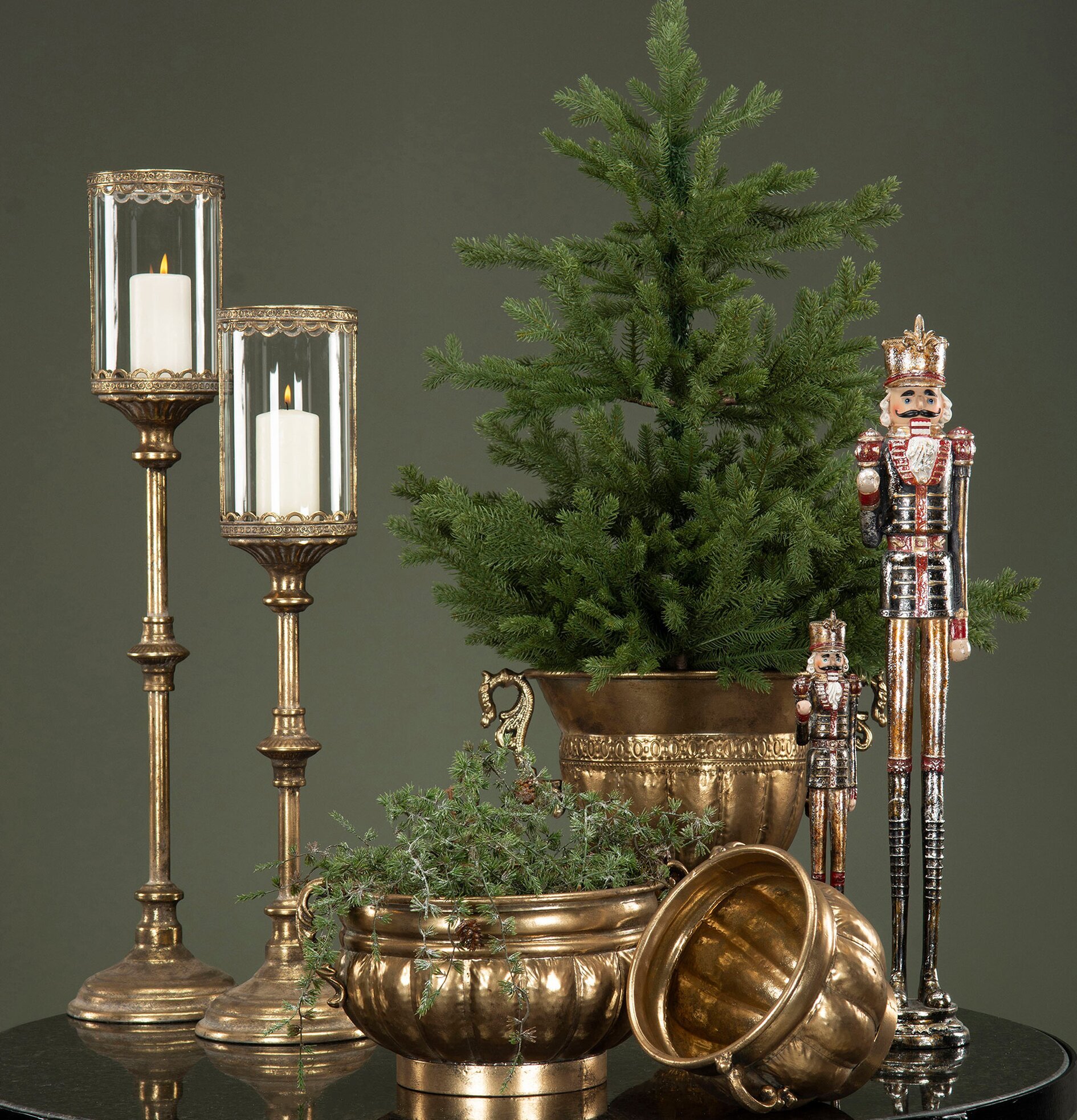 Bild med ljuslyktor, nötknäppare och vintergrön dekoration