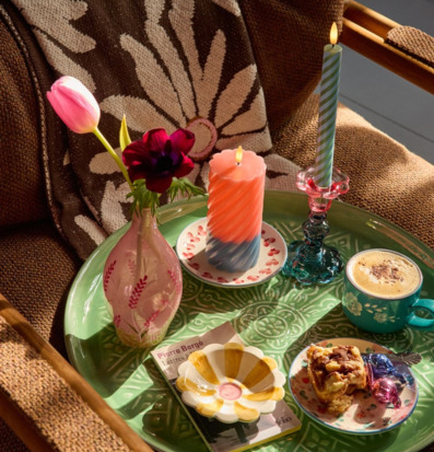 Bild av harmonisk fika med färgstarka ljus och blommor