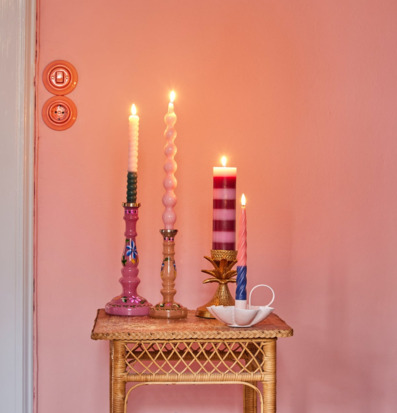 Bild av dekorativt ljusarrangemang på rottingbord i pastell