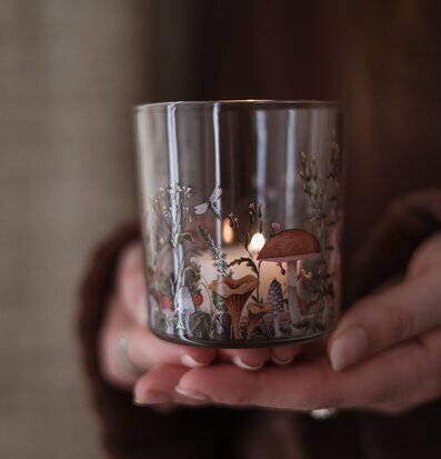 Bild på detaljrik ljuslykta med skogsmotiv och varmt ljus