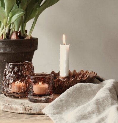 Bild av rustikt bord med ljuslyktor, tulpaner och linneservett