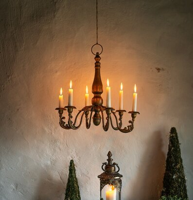 Bild av stämningsfull inomhusmiljö med ljuskrona och lyktor