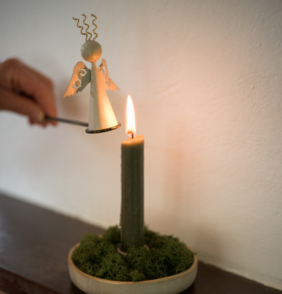 Bild av ängel-ljussläckare i hemmiljö med tänd ljuslykta