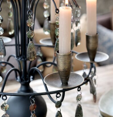 Bild på antiksvart ljusstake med prismor i hemtrevlig miljö