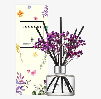 Bild på stilrena doftpinnar med blommor och glaskolv