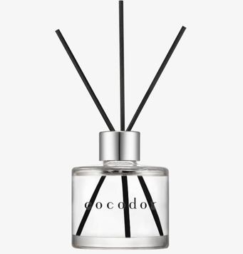 Bild av eleganta doftpinnar i glasflaska med svart trädesign