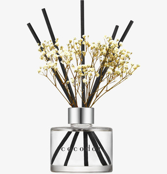 Bild på eleganta doftpinnar med blommor och stilren glasflaska