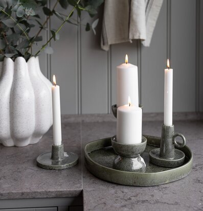 Bild på stilrent kök med gröna ljusstakar och eukalyptusblad