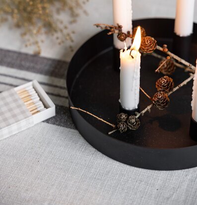 Bild av stilren svart cirkelformad ljusstake med vita ljus