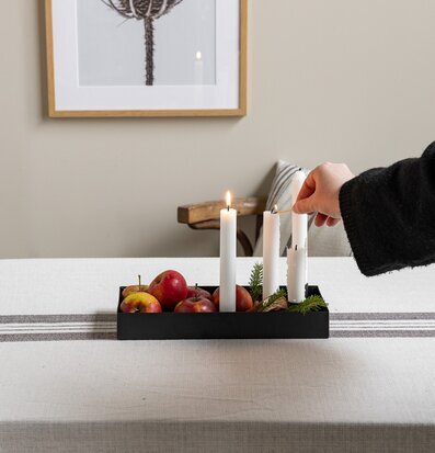 Bild av harmoniskt dukat bord med svart ljusstake och äpplen