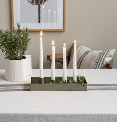 Bild av harmoniskt dukat bord med grön ljusstake och växter