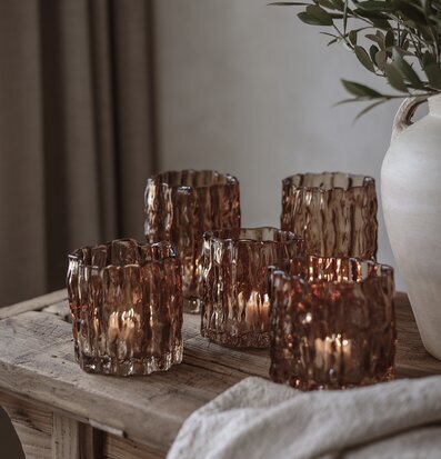 Bild med kastanjebruna ljuslyktor på rustikt träbord