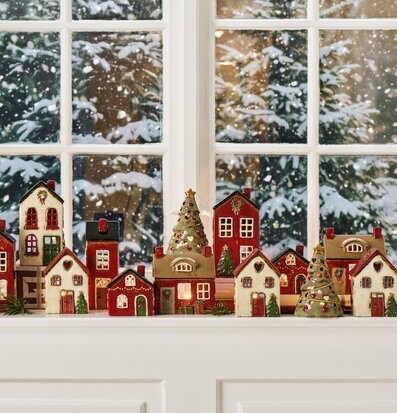 Bild: Vinterfönster med keramikhus och julgranar som ljuslyktor