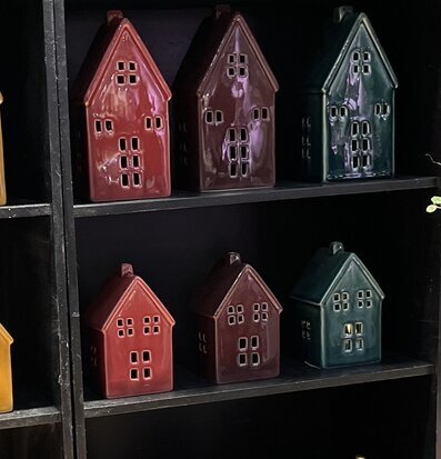 Bild av färgglada ljuslyktor i form av hus på svart hylla