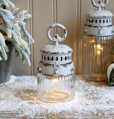 Bild av vintrig lanterna med konstsnö och varm ljusstämning