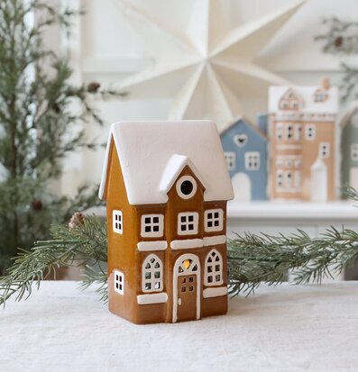 Bild av dekorativ ljuslykta som vintrigt hus med snötak