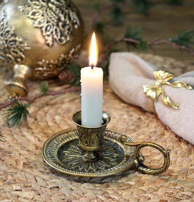 Bild av antik mässingsljusstake med juldekoration och jute