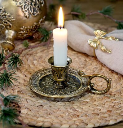 Bild av antik mässingsljusstake med rustik dukning och värmeljus