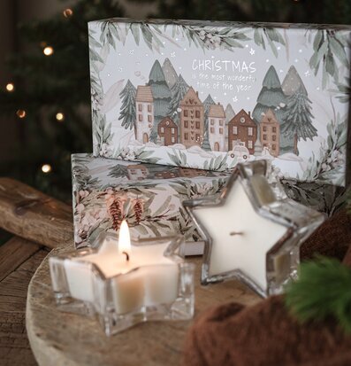 Bild av stämningsfull vinterdekoration med doftljus och gran