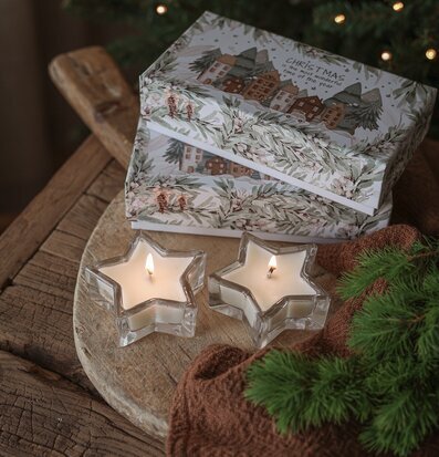 Bild av vinterstämning med stjärnformade doftljus och gran