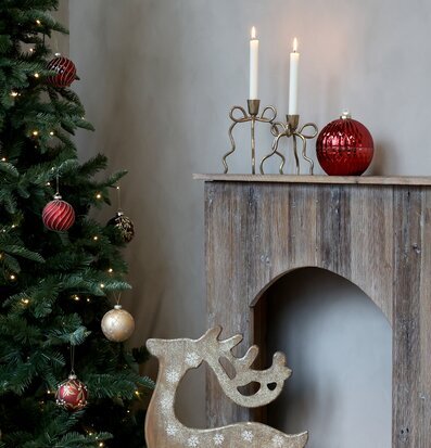 Bild av julgran, ljusstake och ren i varm vinterinredning