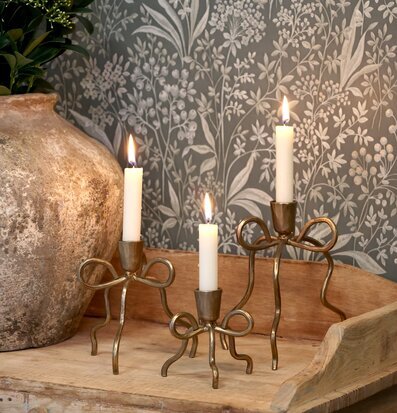 Bild av nordisk inredning med mässingsljusstakar och träbyrå