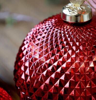 Bild av röd julkula med mönstrad yta och gyllene fäste