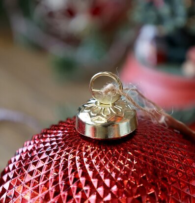 Bild på röd julkula med geometrisk yta och guldhätta