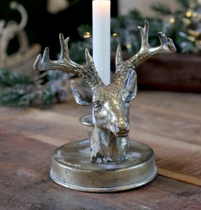 Bild av antik mässingsljusstake med hjorthuvud i vintermiljö