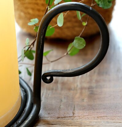 Bild på kammarljusstake i metall med blockljus och växt