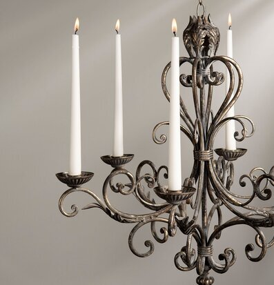 Bild av takmonterad ljuskrona med fyra tända ljushållare