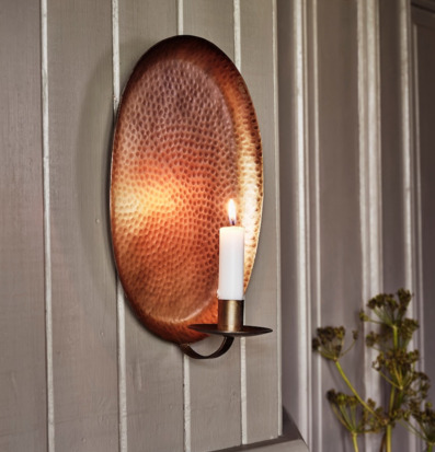 Bild av väggljusstake i antik mässing mot klassisk panel