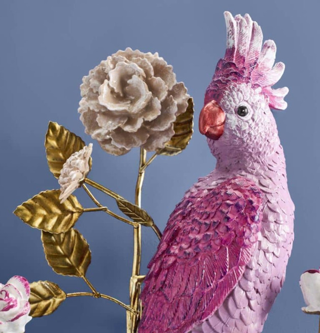 Foto av väggljusstake med rosa papegoja och blad