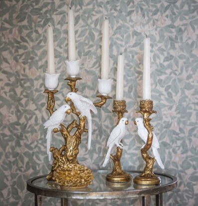 Foto: Guldfärgade ljusstakar med vita fåglar på gren