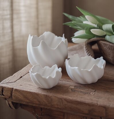 Bild: Vita keramiklyktor på rustik träbänk med tulpaner