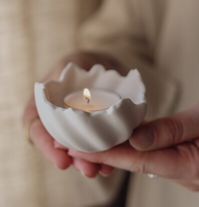 Foto: Handhållen vit ljuslykta med tänd låga