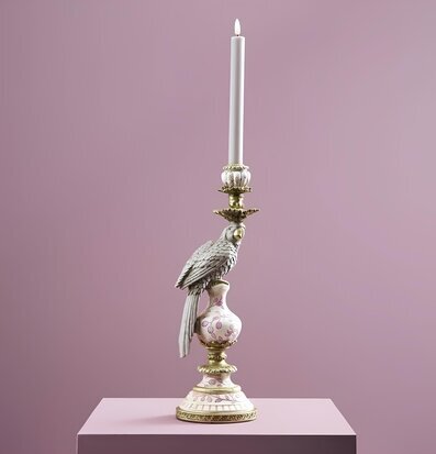 Foto: Ljusstake med papegoja och tänt ljus rosa bakgrund