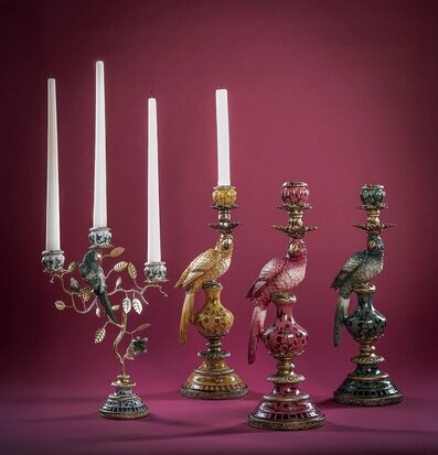 Foto: Papegojljusstakar och kronljus mot vinröd bakgrund