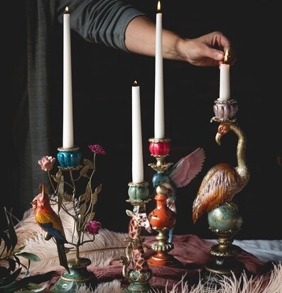 Foto: Hand tänder kronljus i färgstarka ljusstakar
