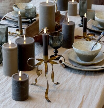 Foto av dukat bord med LED-ljus och glas i beige ton