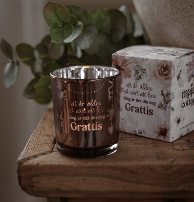 Foto: Ljuslykta i tonat glas med gåvobox, grattis