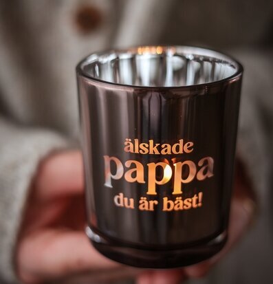 Foto: Tänd ljuslykta i rökfärgat glas med text﻿