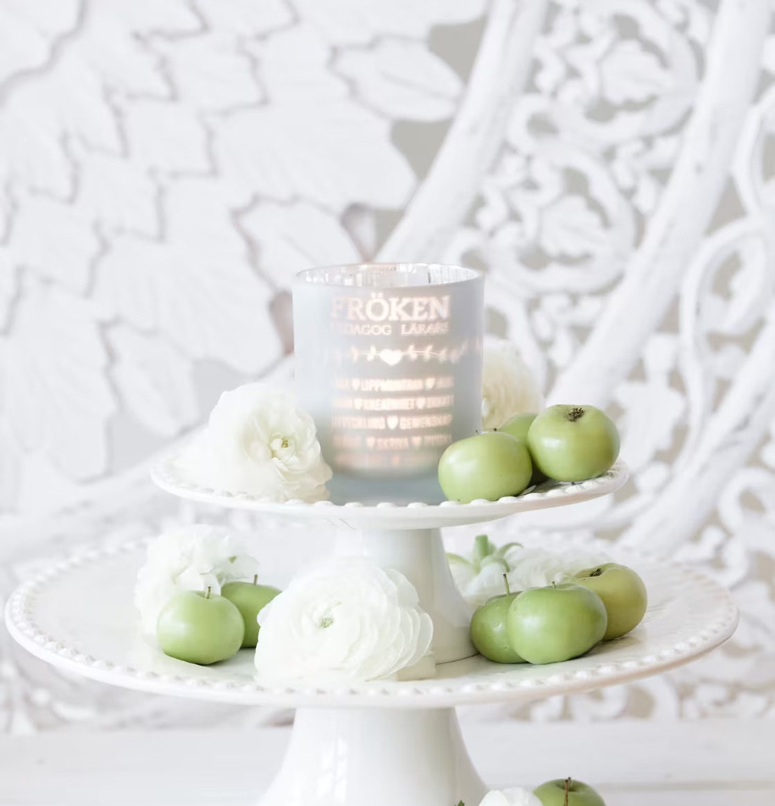 Foto av smakfullt arrangemang med ljuslykta och äpplen