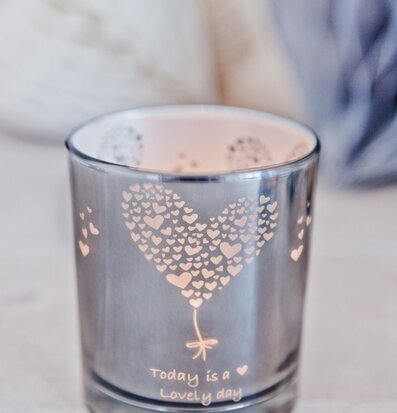 Bild av elegant ljuslykta med hjärtmönster och text