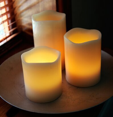 Bild av tre ljuslyktor på metallfat i varm atmosfär