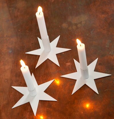 Bild av eleganta stjärnformade ljusstakar i kopparfärg